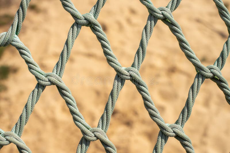 Playground Safety Net Over a Sandy Background. Knotless Rope Stock