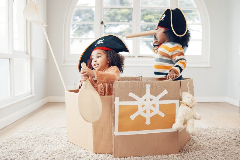 Playing, box boat and pirate children role play, fantasy imagine or pretend in cardboard container. Telescope, fun home royalty free stock photography
