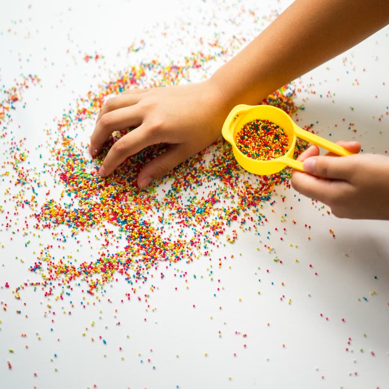 Playing with the colourful sugar sprinkles. Fun activities for children. Fine motor skills