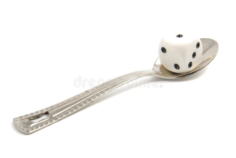 The playing dice and silver spoon isolated on the white background