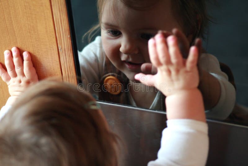 Un nino 10 un mes viejo su reflexión en horno puerta.