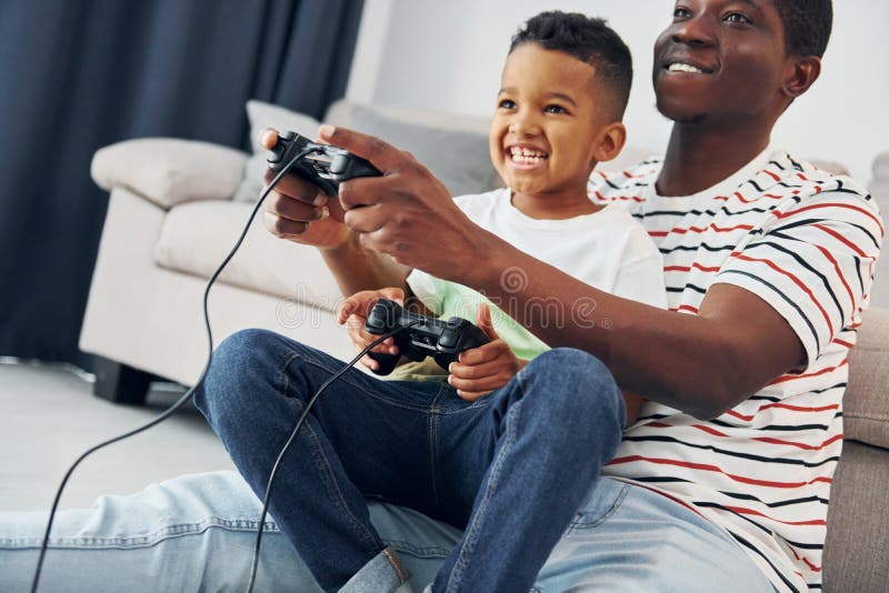 Father and Son Playing Video Games --- Image by © Royalty-…