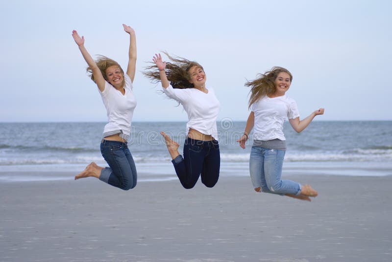 Three teenage girls jumping for joy at the beach. Three teenage girls jumping for joy at the beach