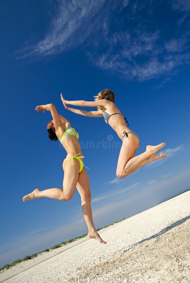 Two cute girls jumping on a beach. Two cute girls jumping on a beach