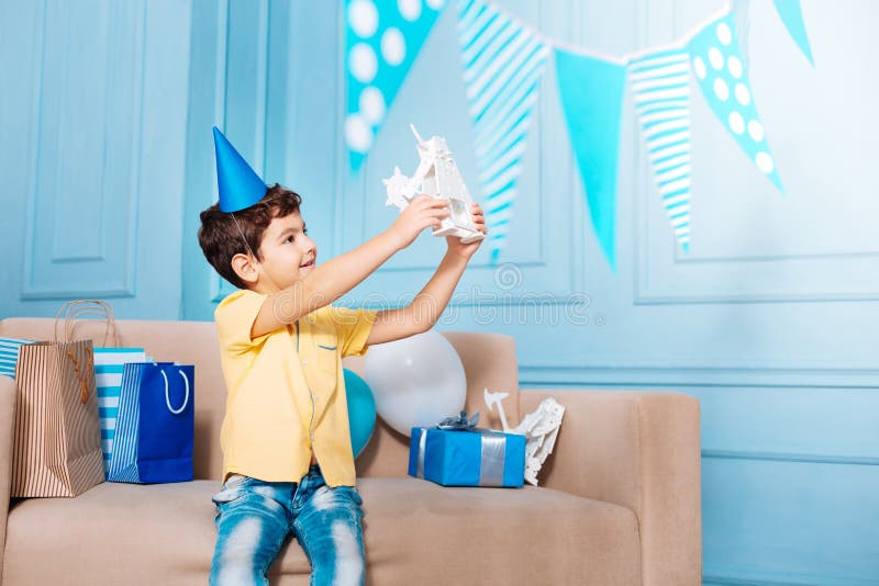Pleasant little boy admiring his birthday gift royalty free stock images Pleasant little boy admiring his birthday gift royalty free stock images