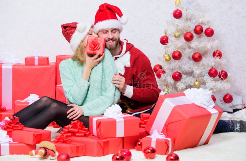 Pleasant surprise. Couple sit near pile of gift boxes and christmas tree background. Husband prepared christmas surprise stock photos Pleasant surprise. Couple sit near pile of gift boxes and christmas tree background. Husband prepared christmas surprise stock photos