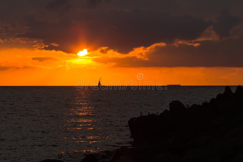Pleasure boat is sailing in a harbor to the Gulf of Riga in a sunset light, on cloudy weather royalty free stock image Pleasure boat is sailing in a harbor to the Gulf of Riga in a sunset light, on cloudy weather royalty free stock image