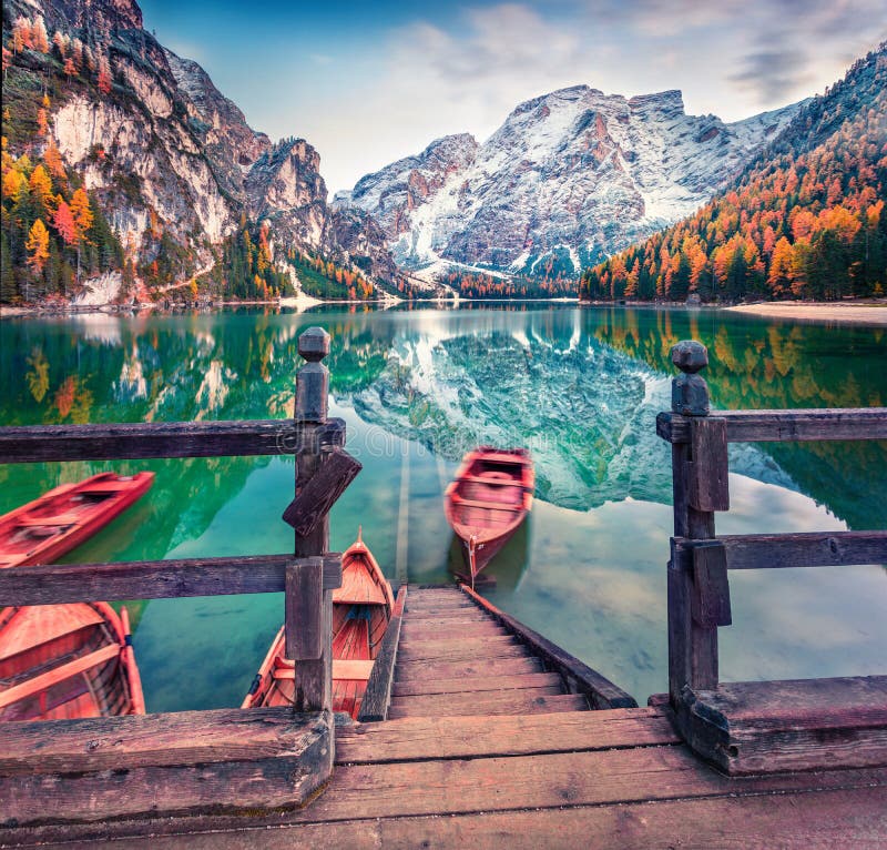 Pleasure boats on Braies Lakeand Seekofel mount on background. Colorful autumn morning in Italian Alps, Naturpark Fanes-Sennes-