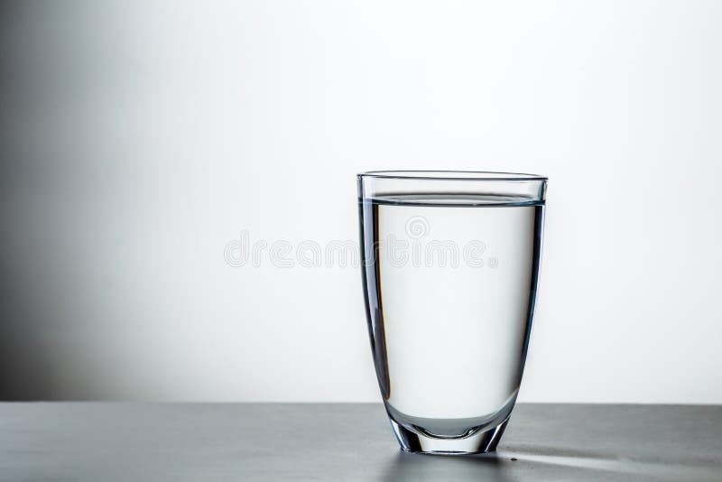 Plein verre sur le fond gris photographie stock Plein verre sur le fond gris photographie stock