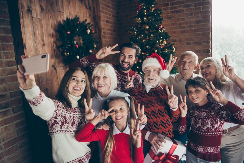 Pleine famille gaie montrant le v-signe de festure de deux doigts Gat de Noel