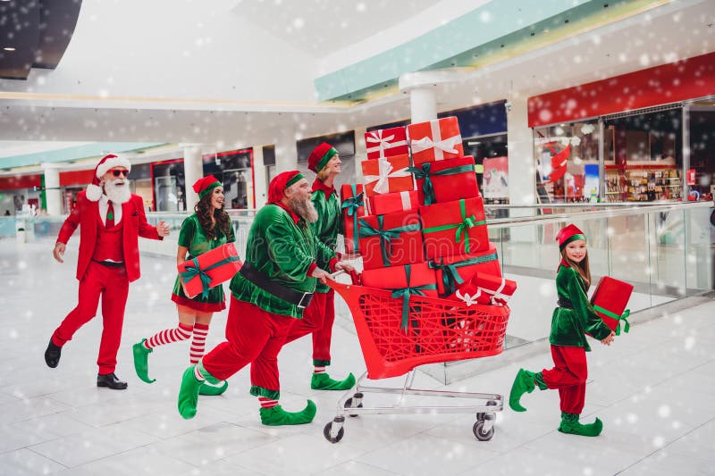 Pleine longueur taille du corps vue de séduisante enjouée groupe elfs courant acheter porter cadeaux christmastime eve. Taille du corps pleine longueur vue de séduisante enjouée groupe elfs courant achat porter cadeaux christmastime eve tradition au magasin intérieur.