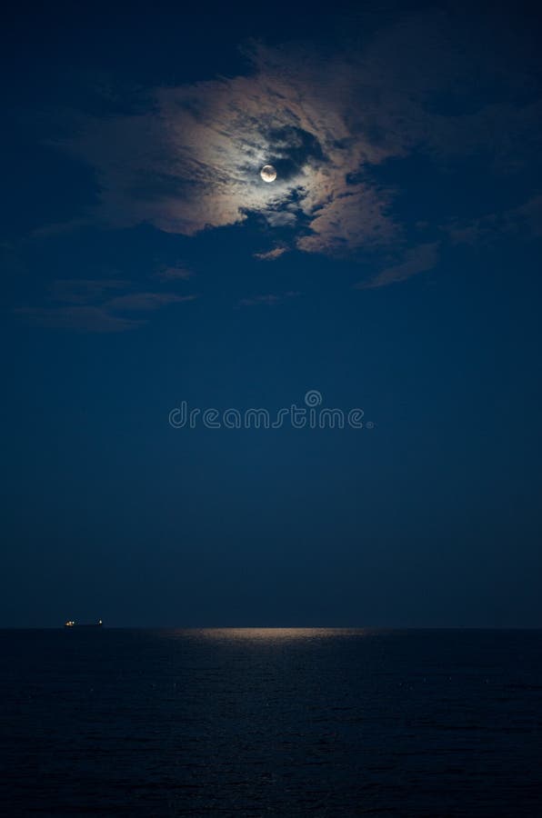 Pleine lune dans un nuage et la mer la nuit image stock Pleine lune dans un nuage et la mer la nuit image stock