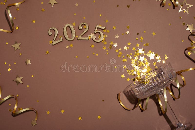 Plenarmode - nyårssammansättning med guldchampagneflaskstjärnor och 2025 nummer på brun bakgrund. plana royaltyfria foton