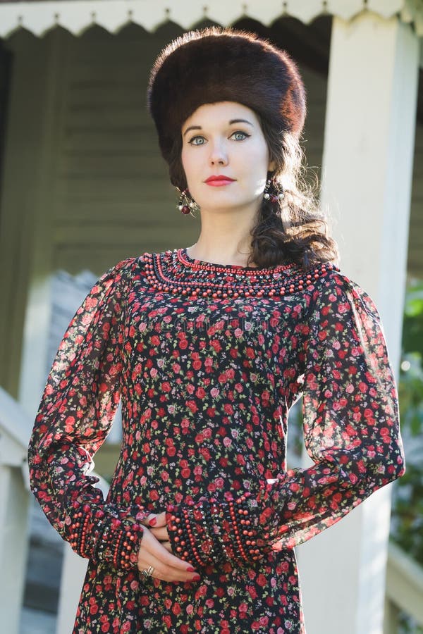 Plenerowy moda portret młoda kobieta w Rosyjskiej średniowiecznej stylowej odzieży z futerkowym Kozackim kapeluszem obrazy stock Plenerowy moda portret młoda kobieta w Rosyjskiej średniowiecznej stylowej odzieży z futerkowym Kozackim kapeluszem obrazy stock