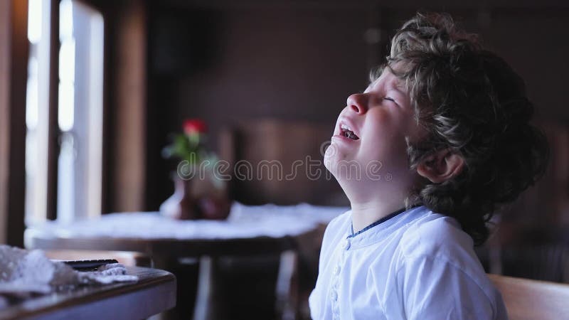 Pleurer de garçon Cri bouleversé de petit enfant au café