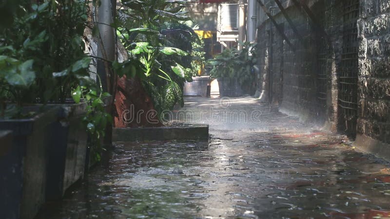 Pleuvoir la chute sur des usines dans la rue vide dans Mumbai