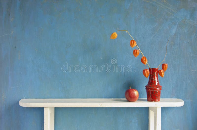 Plewy pomidorowa roślina kwitnie w wazie na białej drewnianej półce
