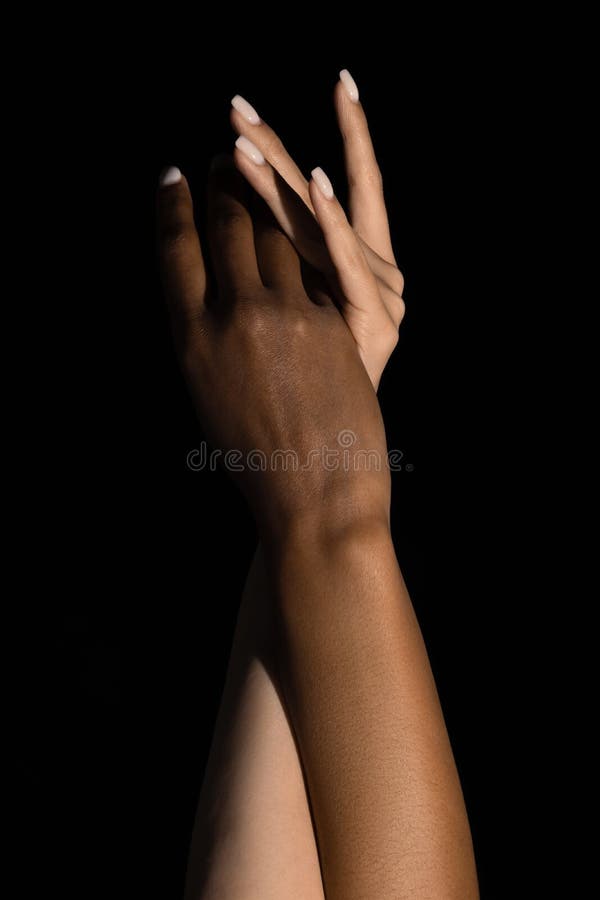 Plexus of female hands. Graceful female hands touch each other isolated on dark studio background. Concept of diversity stock photography