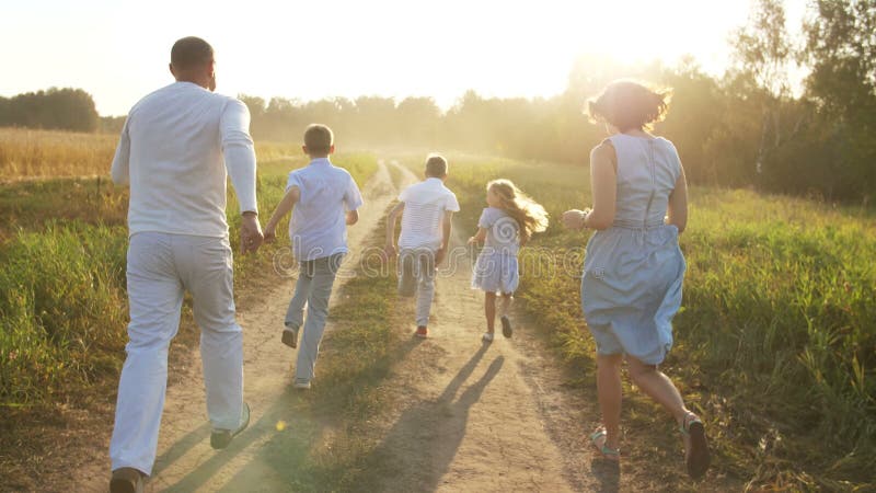 Plimbare cu familia pe un drum rural la apus stock footage