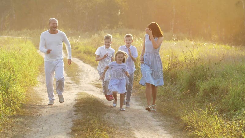Plimbare cu familia pe un drum rural la apus stock video