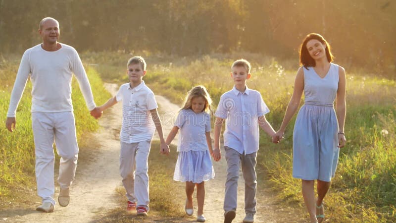 Plimbare cu familia pe un drum rural la apus stock video footage