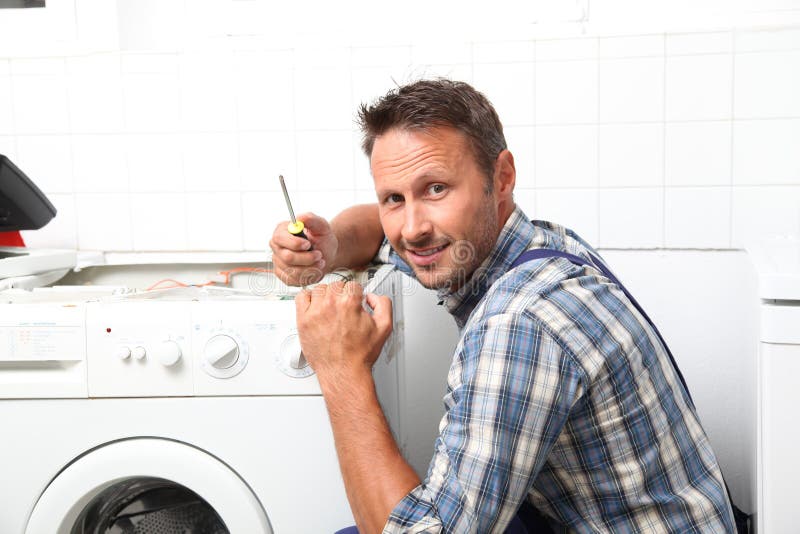 Plombier travaillant à l'appareil ménager Plombier travaillant à l'appareil ménager