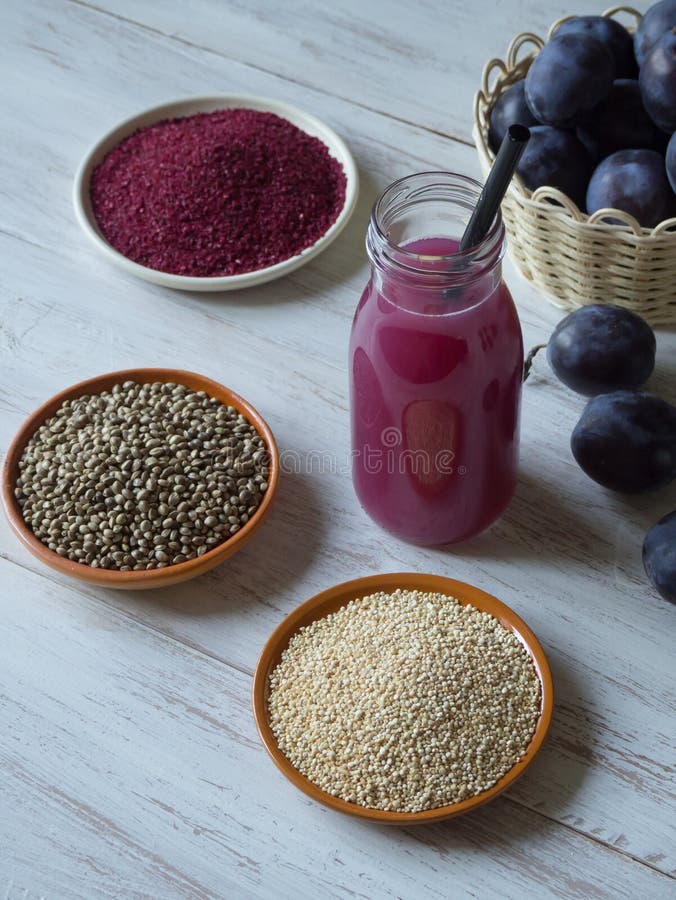 Plommonsmoothie med Superfoods på en vit trätabell Sund mat med tillägg royaltyfri bild Plommonsmoothie med Superfoods på en vit trätabell Sund mat med tillägg royaltyfri bild