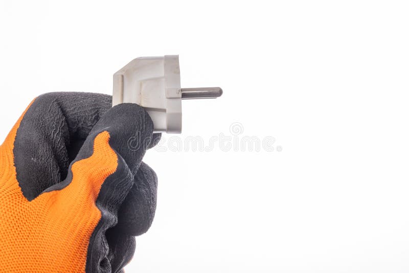The Plug is Held in a Gloved Hand. Electrical Accessories in the
