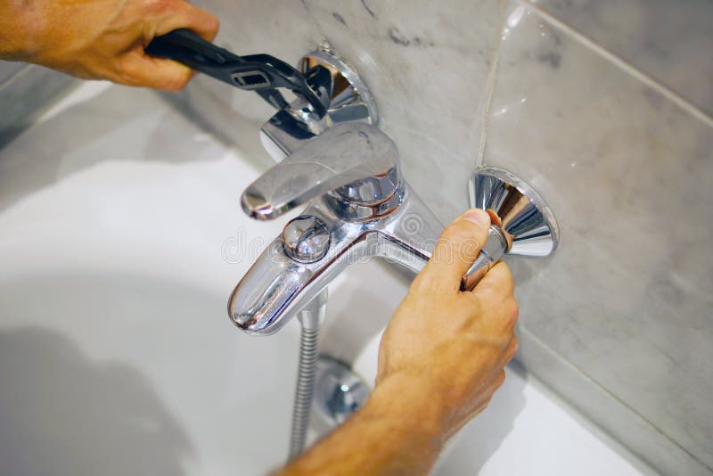Plumber Fixing Bath Faucet With An Adjustable Wrench Stock Image