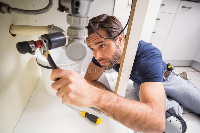 Plumber fixing under the sink stock photography