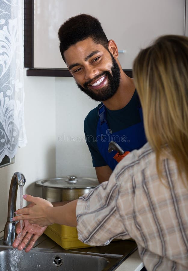 Plumber and Housewife in Kitchen Stoc pic image