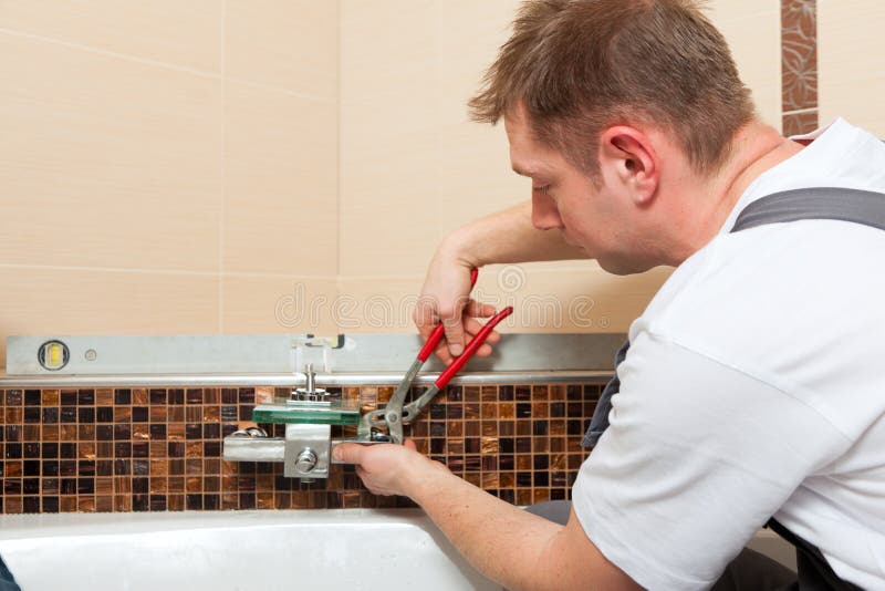 Plumber at Work in a Bathroom, Plumbing Repair Service, Assemble Stock