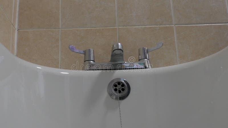 Plumber removing bath overflow drain cover