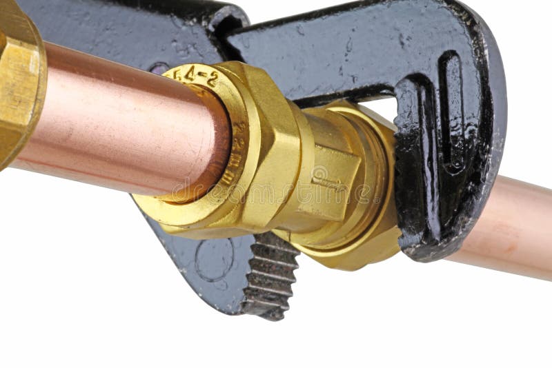 Plumber`s adjustable wrench tightening up copper pipework