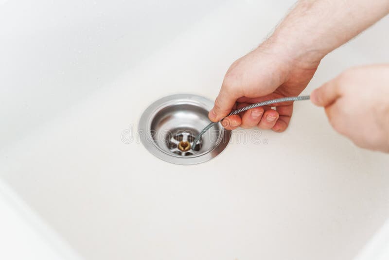 https://thumbs.dreamstime.com/b/plumber-using-drain-snake-to-unclog-kitchen-sink-215948665.jpg