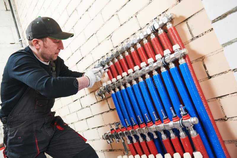 Plumber Work. Installing Collector for Warm Water Underfloor Heating