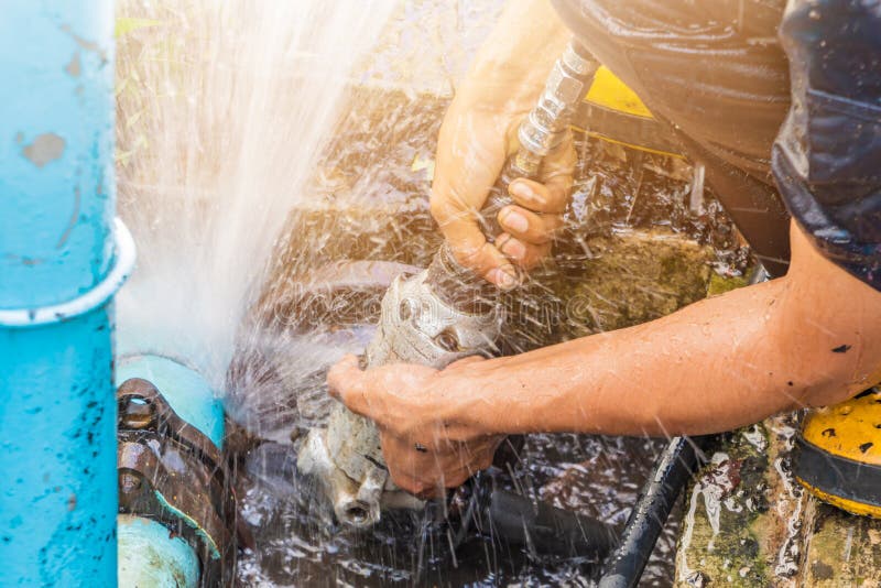 Plumber working repair the broken pipe and replace in hole with water Motion at roadside stock images