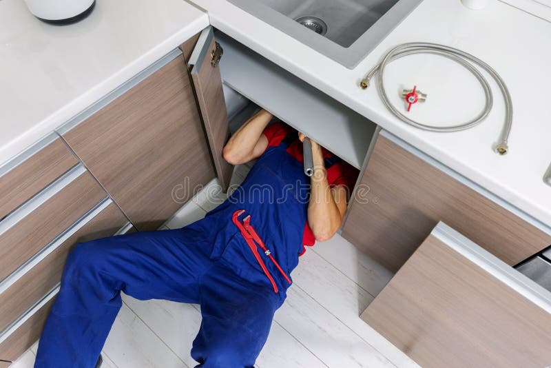 plumber working under domestic kitchen sink royalty free stock images plumber working under domestic kitchen sink royalty free stock images