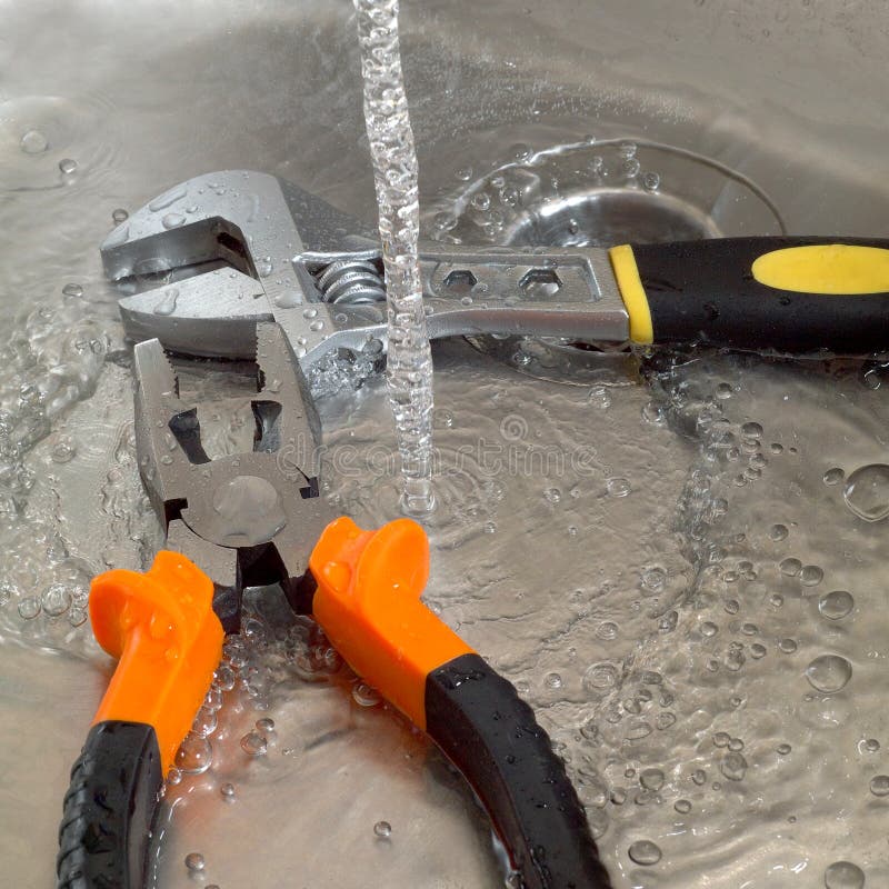 Plumbing Tools Adjustable Wrench and Pliers in a Sink Under Running