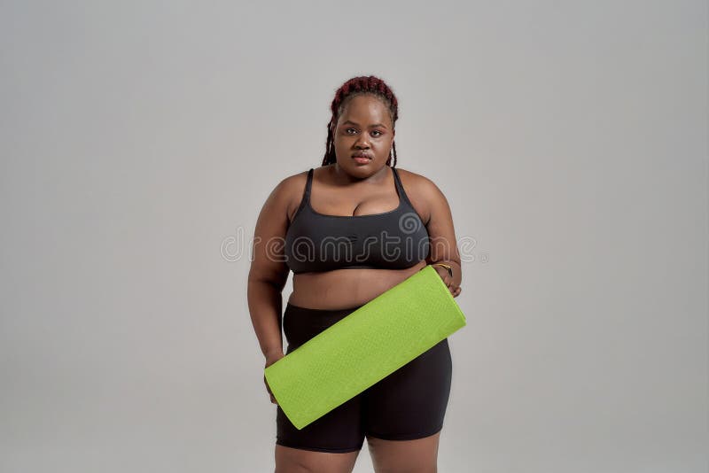 Plump, Plus Size African American Woman in Sportswear Holding Green Yoga Mat for Fitness, Posing in Studio Grey Stock Image Image of loss, athlete: 187892913