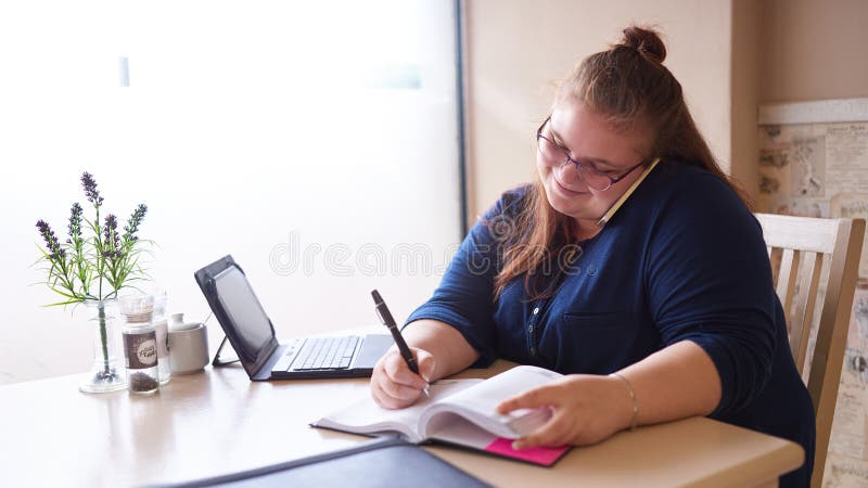 Plus för affärskvinna för format caucasian multitasking i ett ljust kafé fotografering för bildbyråer Plus för affärskvinna för format caucasian multitasking i ett ljust kafé fotografering för bildbyråer