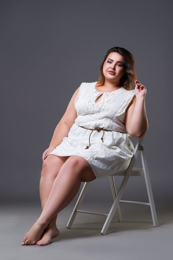 Plus size fashion model in casual clothes, fat woman on gray background