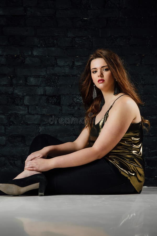 Plus Size Model in a Gold Blouse and Black Jeans on a Loft Background. Stock - Image of face, 108081117