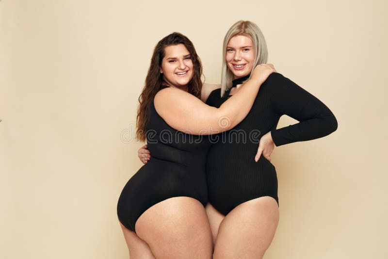 Plus Size Models. Full-figured Portrait. Brunette and Blonde in Black Bodysuits Posing on Beige Background. Stock Photo - Image of looking, lady: