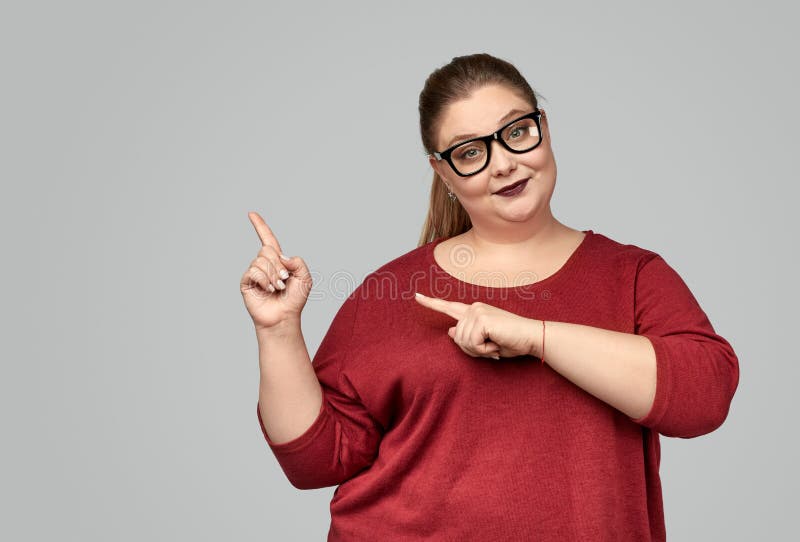 Plus size woman in glasses pointing aside