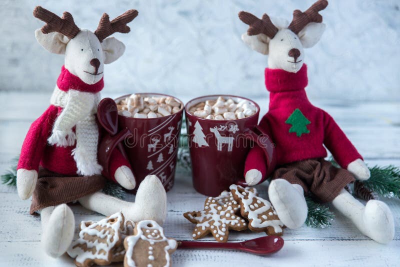 Plush deer with brown mugs with cocoa and ginger cookies stock photos
