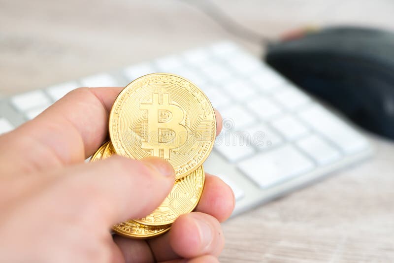 Plusieurs bitcoins dorés dans une main image libre de droits