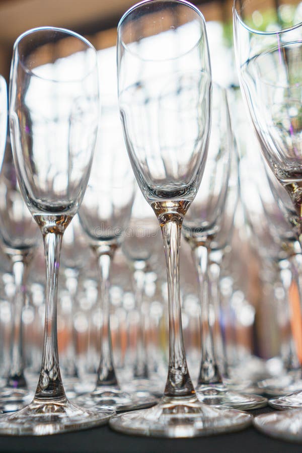 Plusieurs rangées dégagent les verres transparents et propres pour le vin et le champagne sur le compteur préparé pour des boisso photographie stock libre de droits Plusieurs rangées dégagent les verres transparents et propres pour le vin et le champagne sur le compteur préparé pour des boisso photographie stock libre de droits