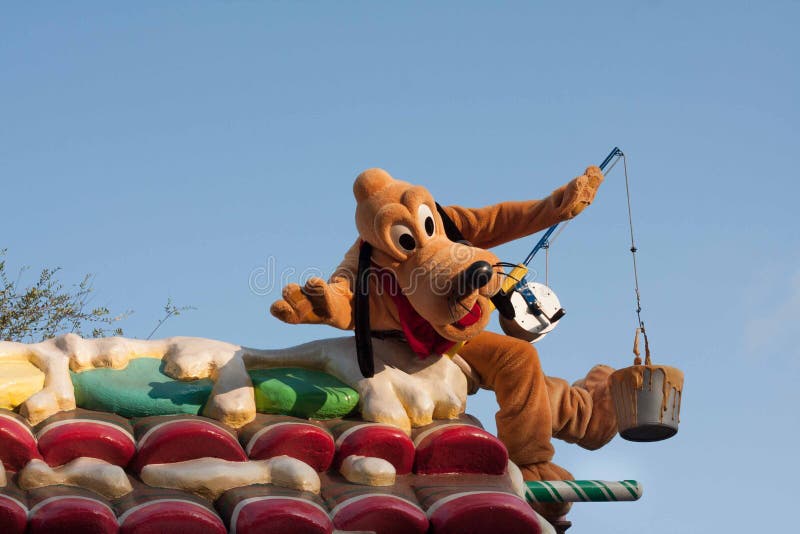 Pluto the Pup is riding on a float in Disneyland's A Christmas Fantasy Parade. Very popular Christmastime parade at Disneyland. He is a cartoon character, red-colored, medium-sized, short-haired dog with black ears. Pluto the Pup is riding on a float in Disneyland's A Christmas Fantasy Parade. Very popular Christmastime parade at Disneyland. He is a cartoon character, red-colored, medium-sized, short-haired dog with black ears.