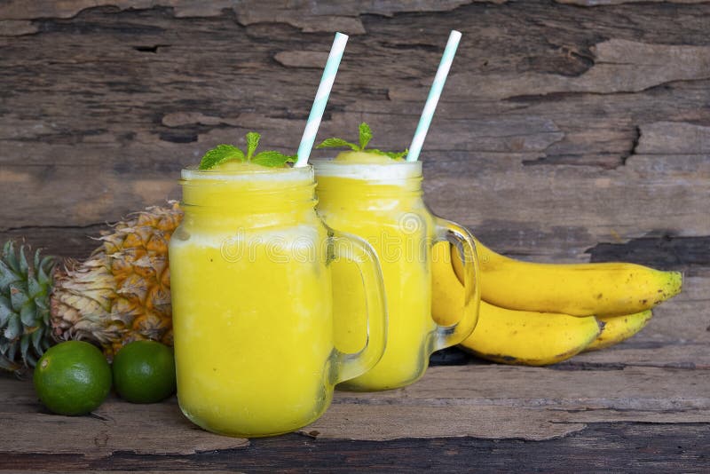 Plátano con la bebida sana amarilla del zumo de la piña y de fruta de los smoothies de las manzanas foto de archivo libre de regalías Plátano con la bebida sana amarilla del zumo de la piña y de fruta de los smoothies de las manzanas foto de archivo libre de regalías